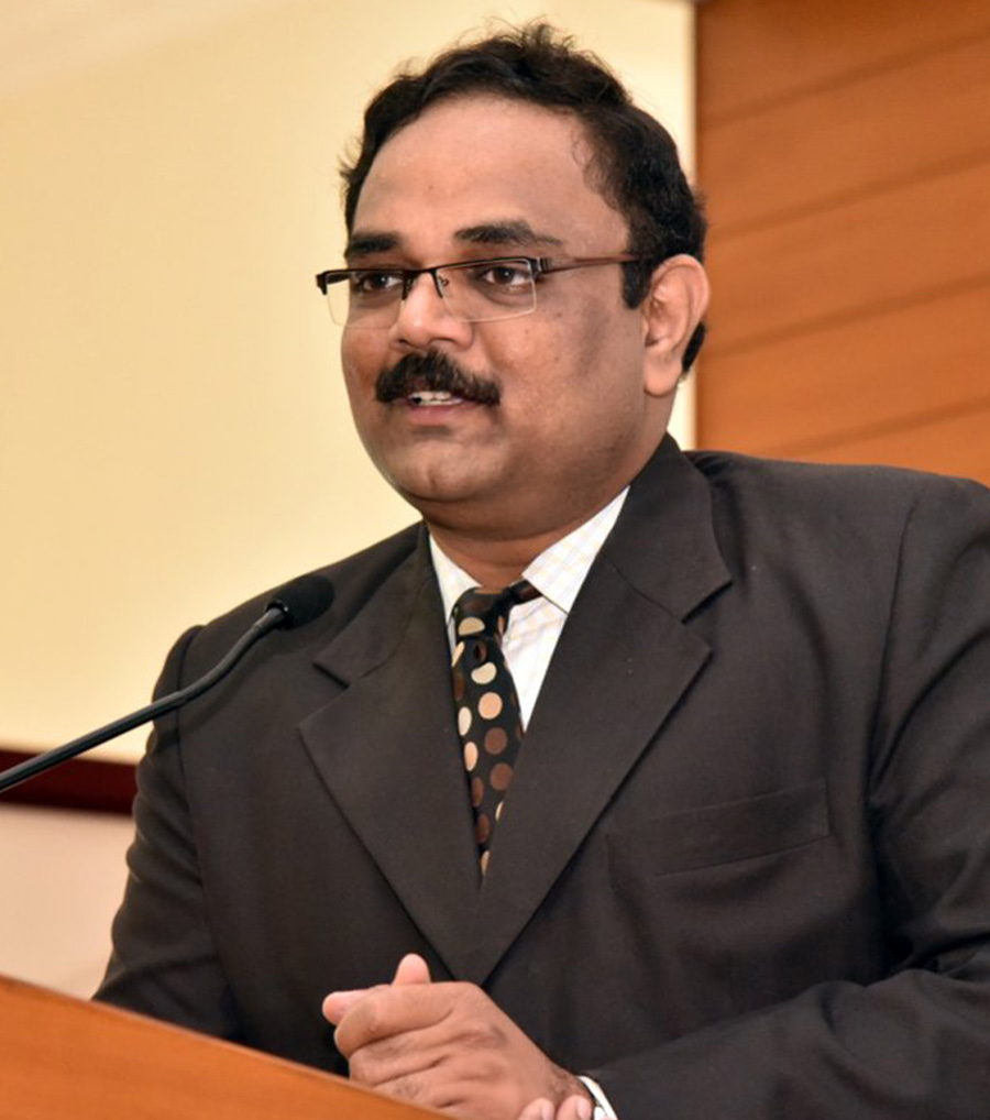 Dr. J. Vijay Venkatraman standing behind a proctor and giving a speech